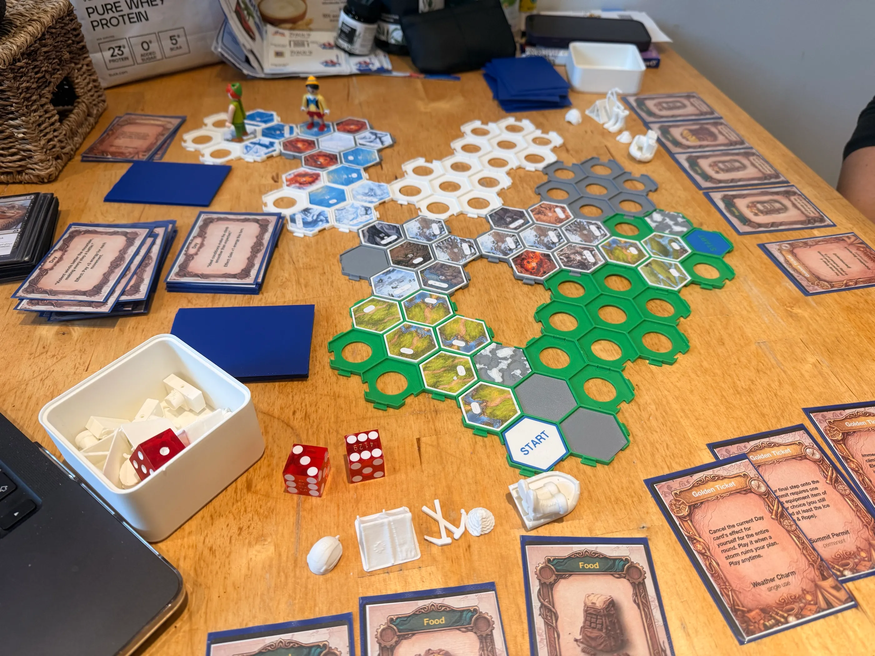 Later in the same game: two climbers on the white frames near the Summit, Golden Tickets laid out beside the board.